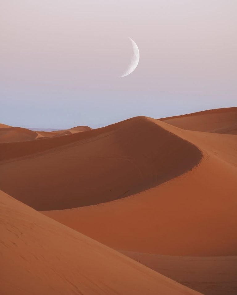 Crescent moon above the Erg Chebbi sand dunes at dusk – Merzouga