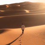 Traveller walking alone across the Erg Chebbi dunes – Merzouga, Morocco