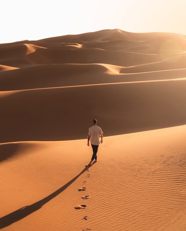Guided Walking Tour Traveller walking alone across the Erg Chebbi dunes – Merzouga
