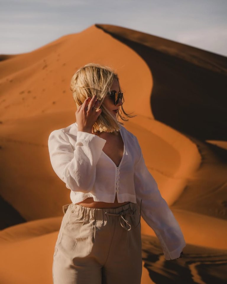 Yoga Retreat in the Sahara Woman in a white shirt standing in the Merzouga dunes – Merzouga