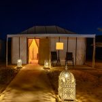 Luxury desert camp tent lit with lanterns at night – Merzouga, Morocco