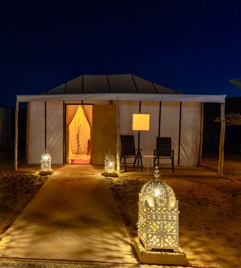 Luxury desert camp tent lit with lanterns at night – Merzouga