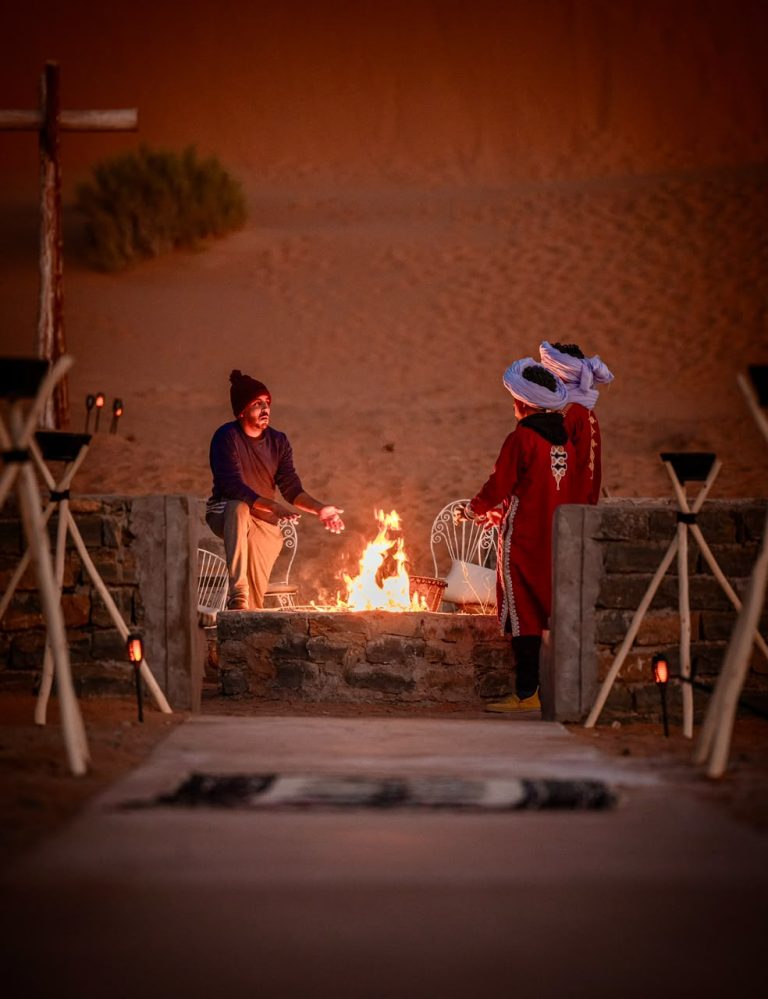 Berber staff at the fire pit of a desert camp at night – Merzouga