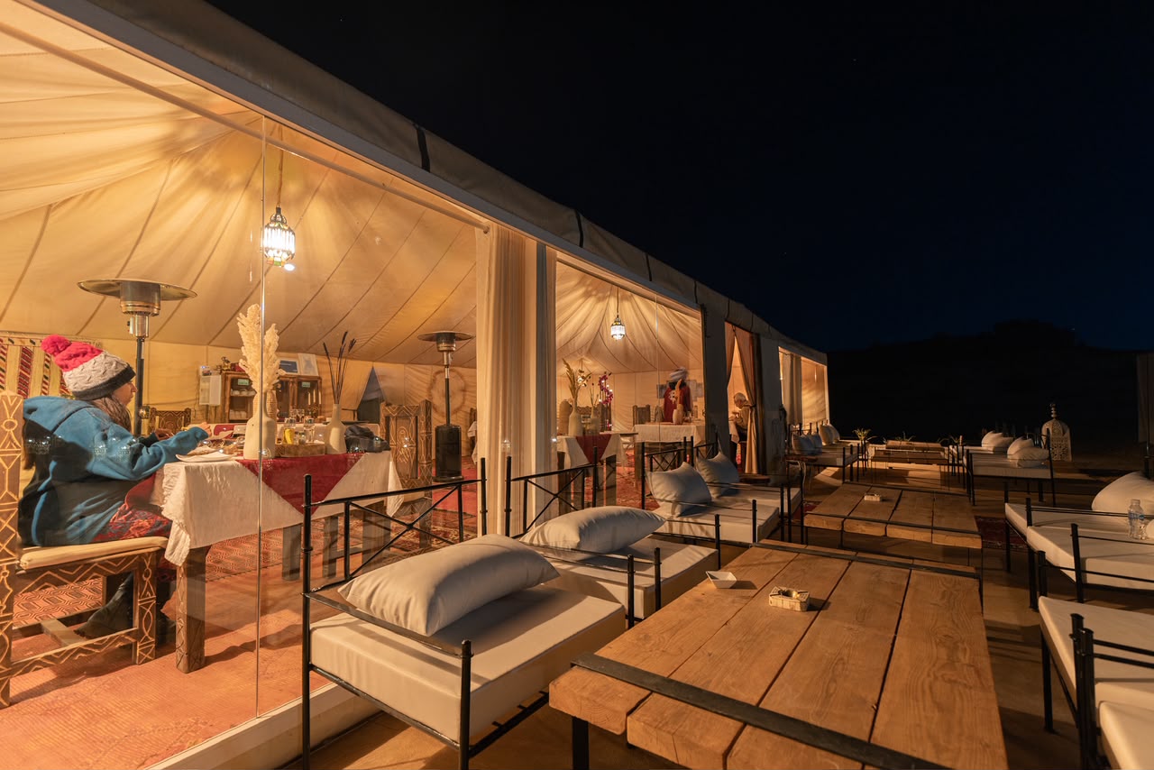 Fire & Drums Night Restaurant tent and lounge terrace of a desert camp at night – Merzouga