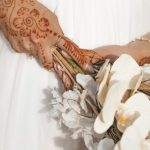 Bride with henna hands holding a white bouquet – Merzouga, Morocco