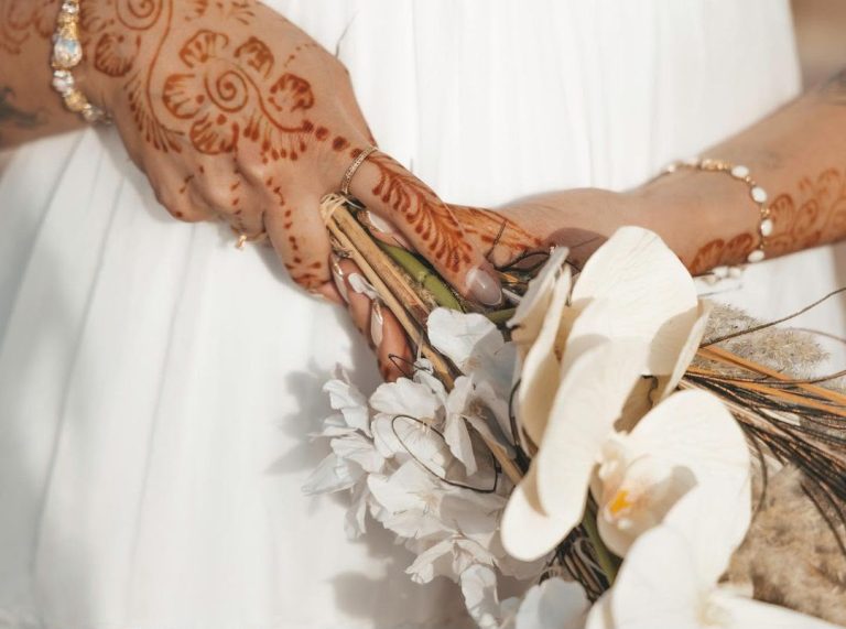 Bride with henna hands holding a white bouquet – Merzouga