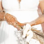 Henna-decorated hands of a bride with flowers – Merzouga, Morocco