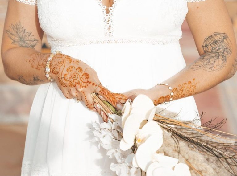 Henna-decorated hands of a bride with flowers – Merzouga