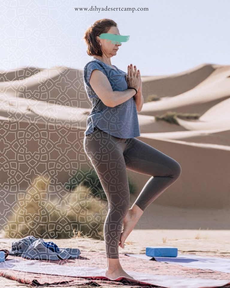 Yoga Retreat in the Sahara Woman in a balance yoga pose on the dunes – Merzouga