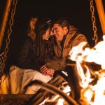 Couple sitting by the campfire on a desert night – Merzouga, Morocco