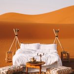 Romantic bed setup on top of the dunes at sunset – Merzouga, Morocco