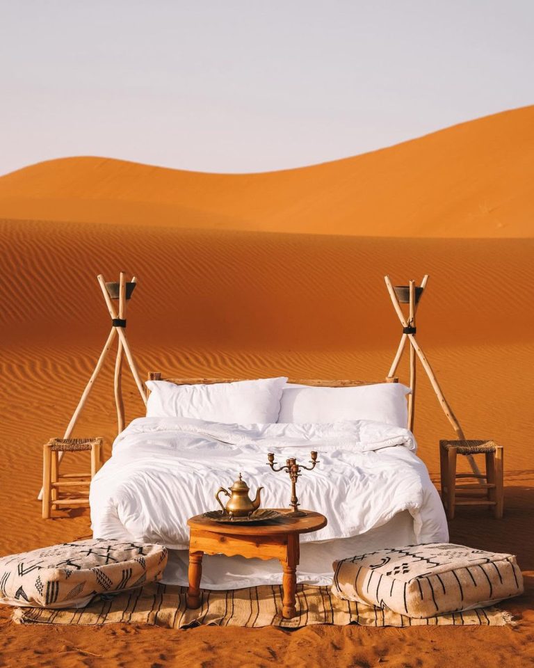 Romantic bed setup on top of the dunes at sunset – Merzouga