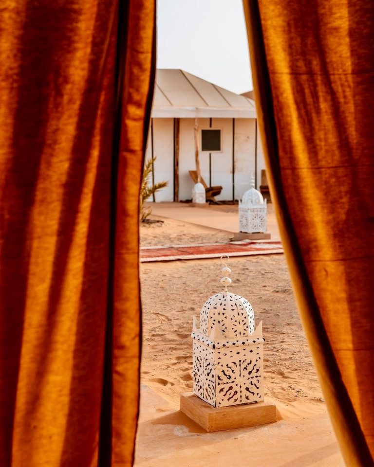 View from a camp tent onto the desert with lanterns – Merzouga