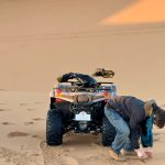 Rider next to an ATV quad bike in the dunes – Merzouga, Morocco