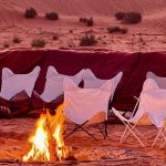 Campfire and chairs set up in the dunes at night – Merzouga, Morocco