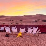 Romantic seating setup in the dunes at sunset – Merzouga, Morocco